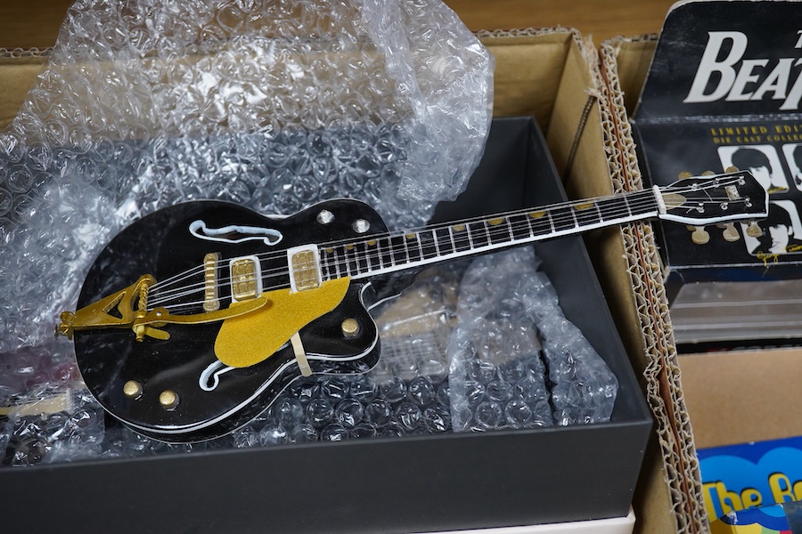 A collection of Beatles memorabilia including; models of a Beatles drum kit and eight miniature guitars and stands, each approx 25cm long, together with three boxed Corgi Beatles related models, including the Yellow Subm